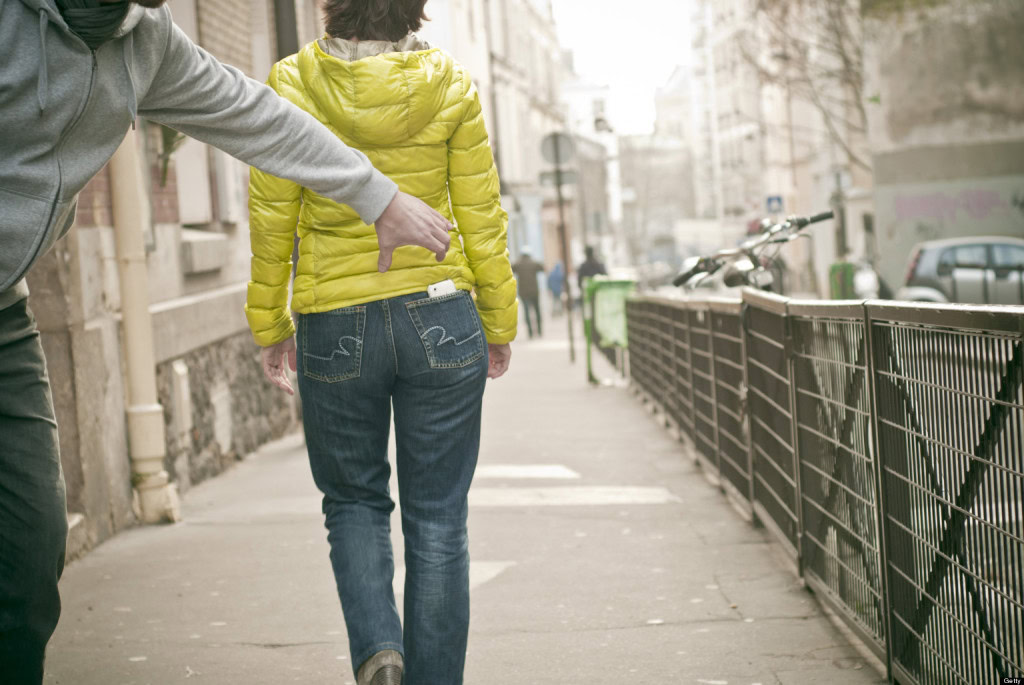 do you need mobile phone insurance? photo of man stealing phone from a woman's back pocket