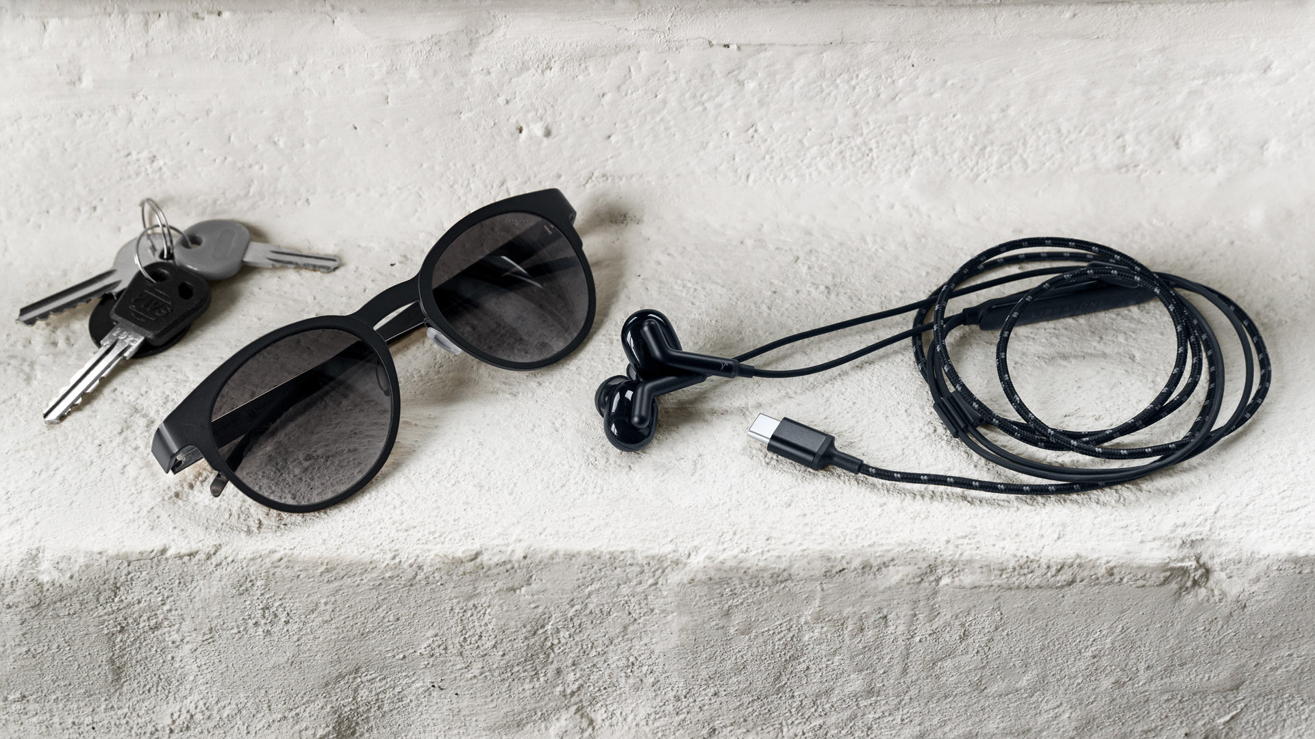 A photo of the Libratone Made for Google Q Adapt In-ear USB-C with keys, and sunglasses.