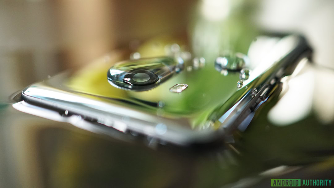 Water beads on the glass back of a smartphone