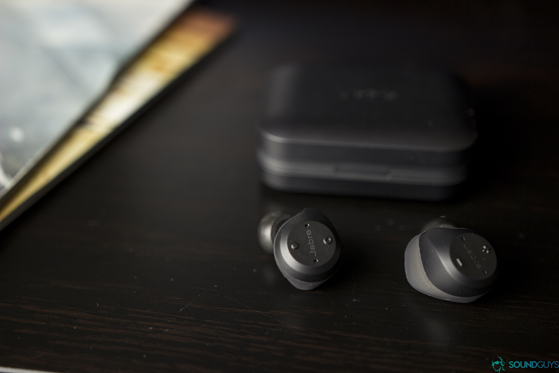 The Jabra Elite 65t in front of its charging case.