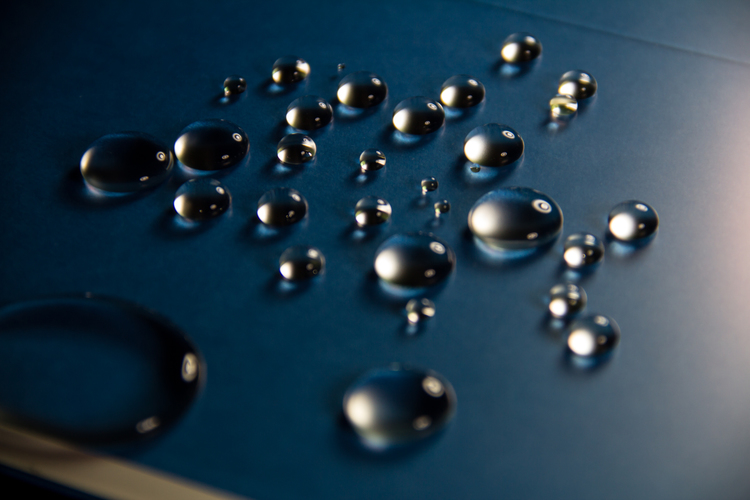 An oleophobic coating on glass showing beads of water