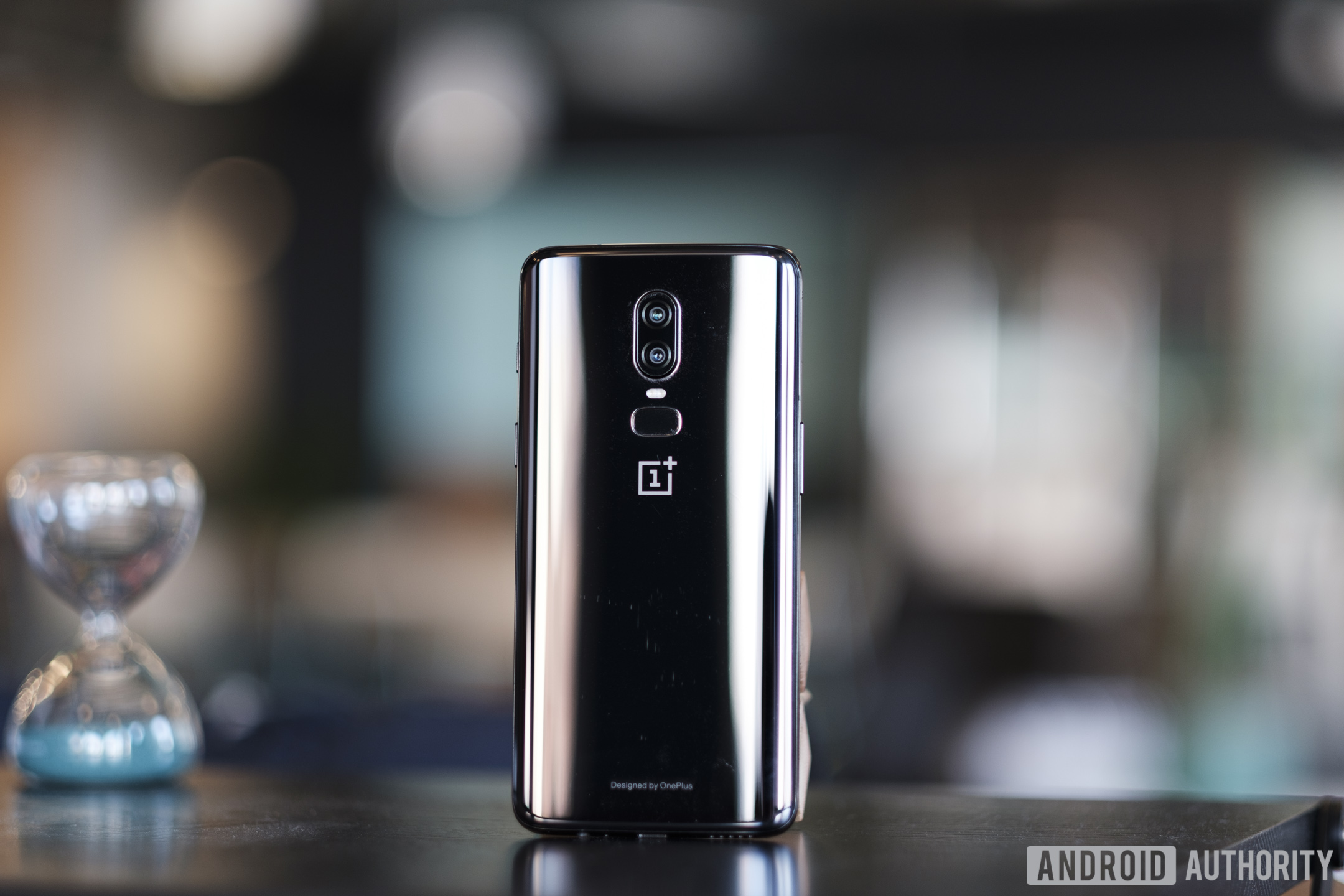 The OnePlus 6 smartphone in black pictured from behind and standing on a table.