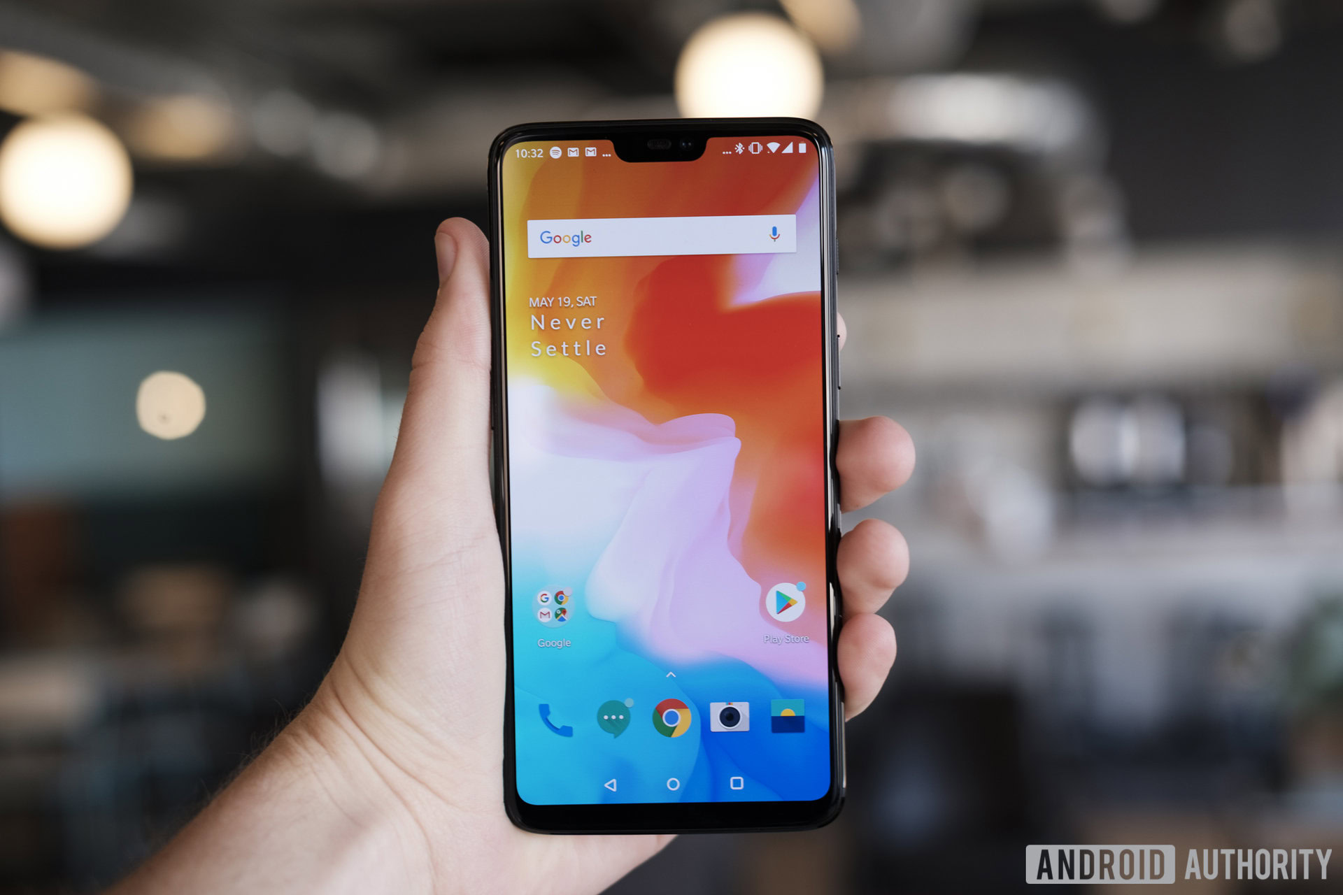 An image of the OnePlus 6 held out in a person's left hand with the screen on.