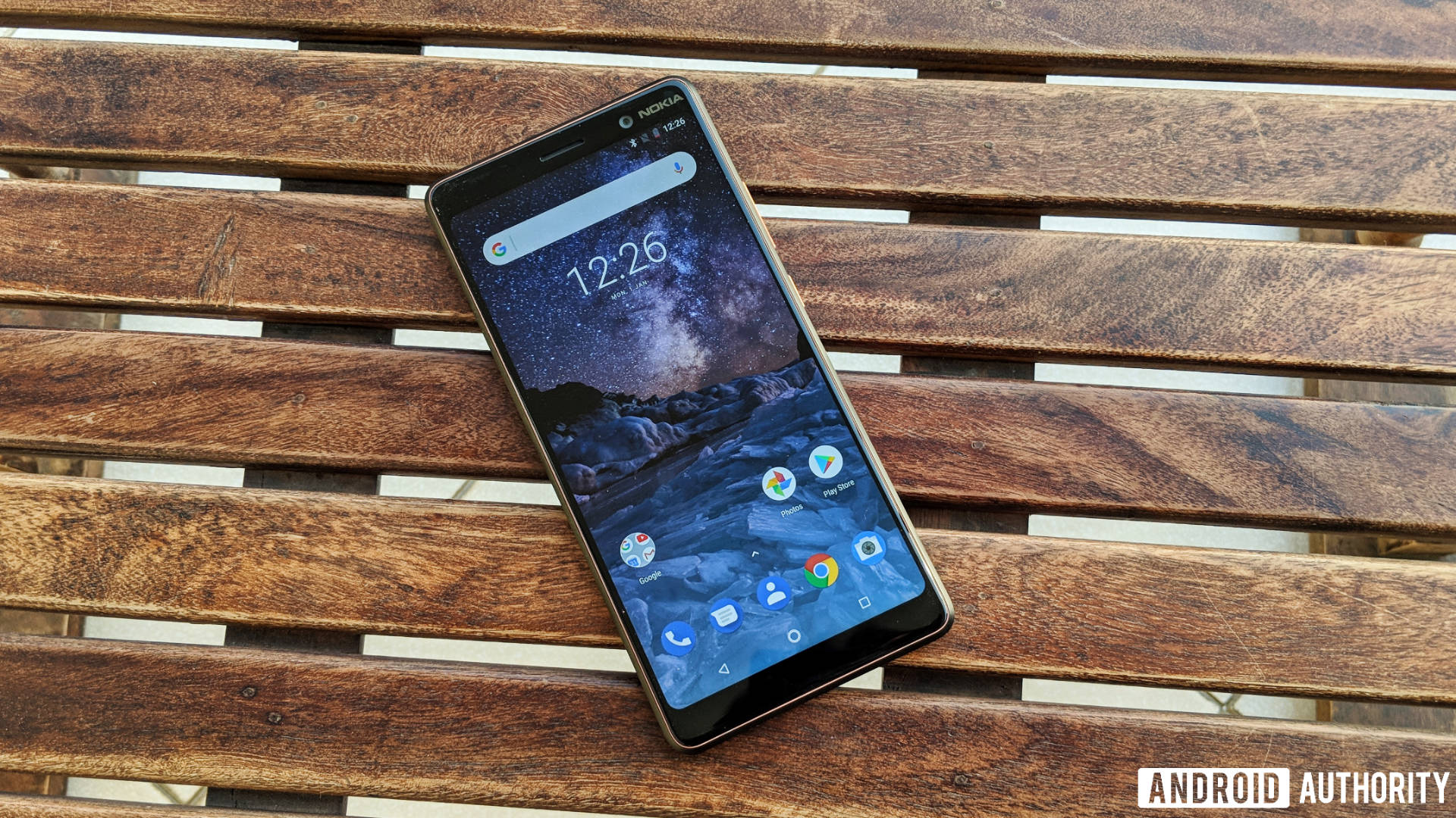 The Nokia 7 Plus on a wooden bench.