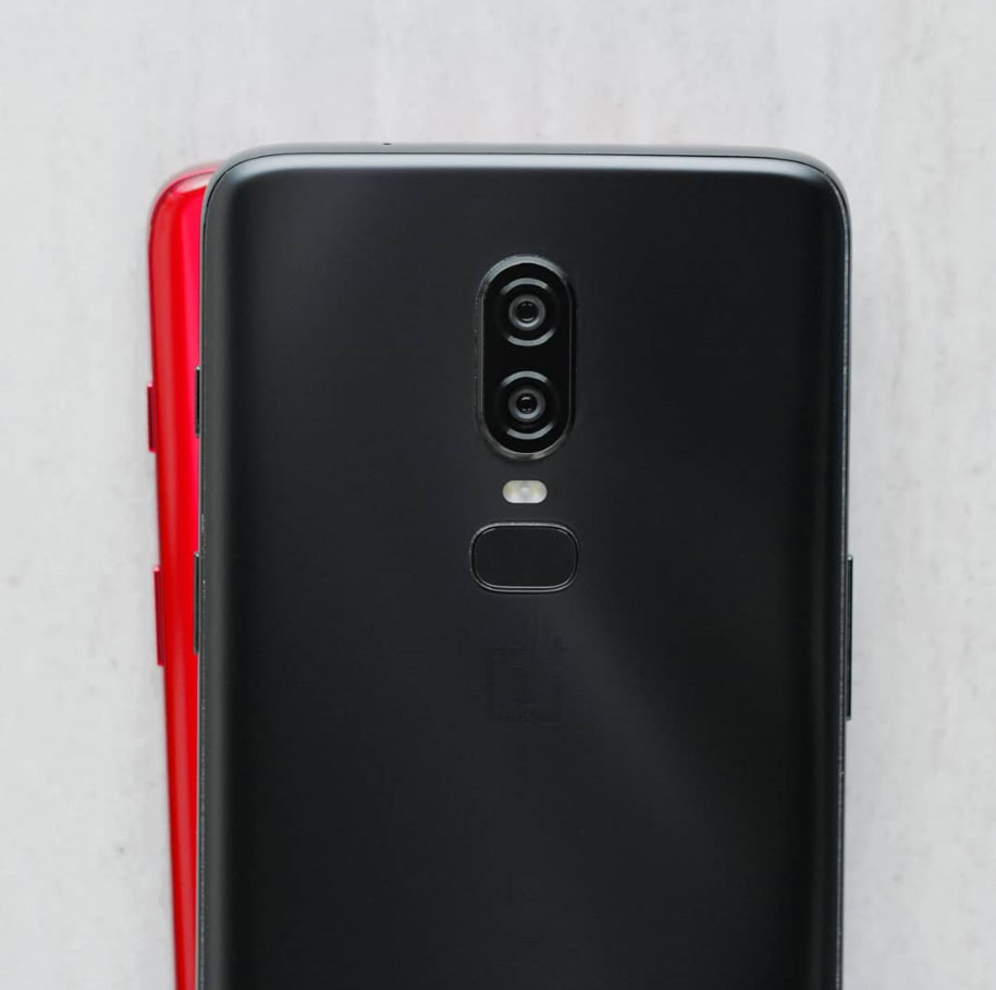 An image that is likely a red OnePlus 6 underneath a black OnePlus 6.