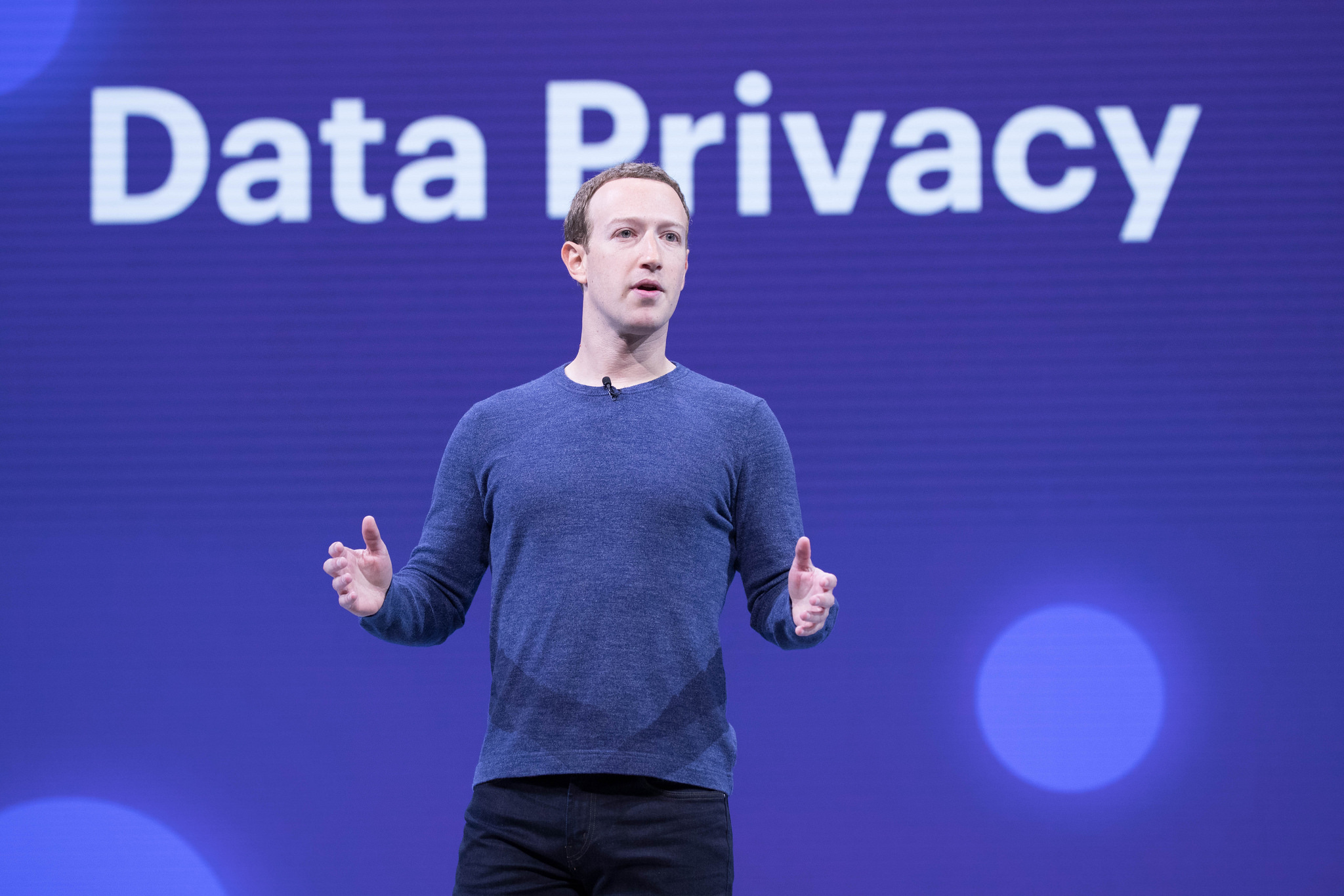An image of Mark Zuckerberg standing in front of a backdrop that says &quot;Data Privacy&quot; in large letters.
