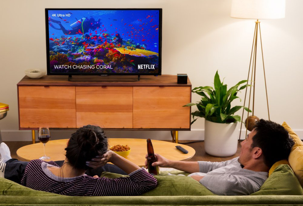 The Amazon Fire TV Cube on a media center in the home of two people.