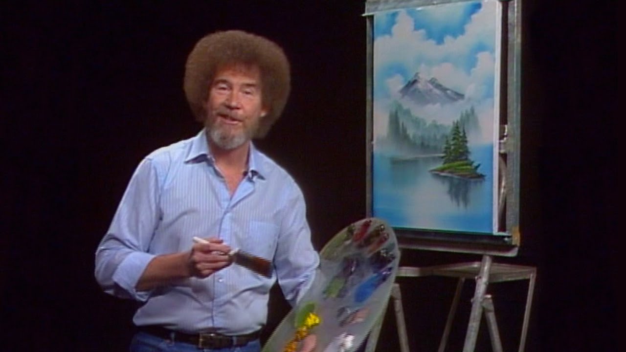 Bob Ross sitting in front of a canvas painting during an episode of &quot;The Joy Of Painting.&quot;