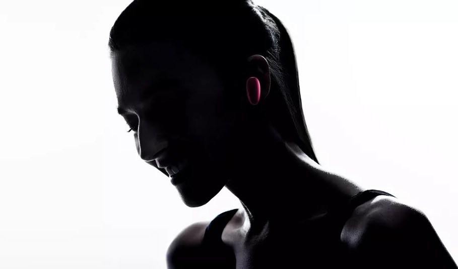A silhouette image of a woman wearing the OPPO O-Free headphones in her left ear.