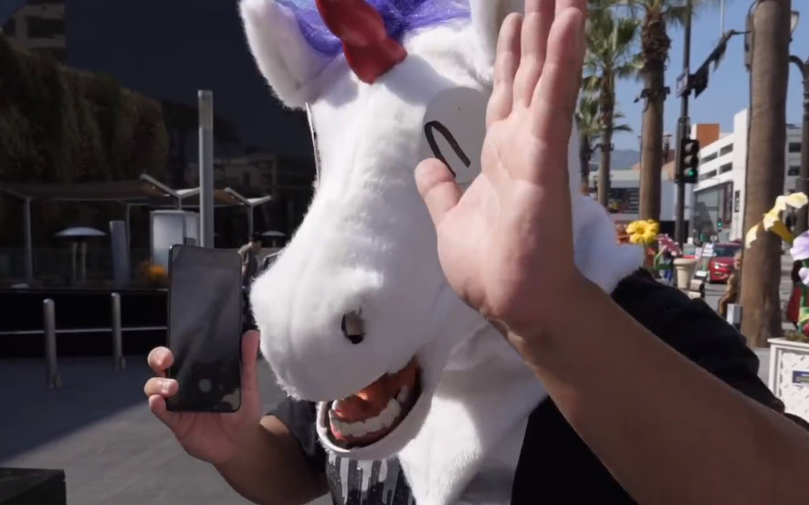 An image of a man with a unicorn mask holding the vivo Nex, showing off its underglass fingerprint sensor.