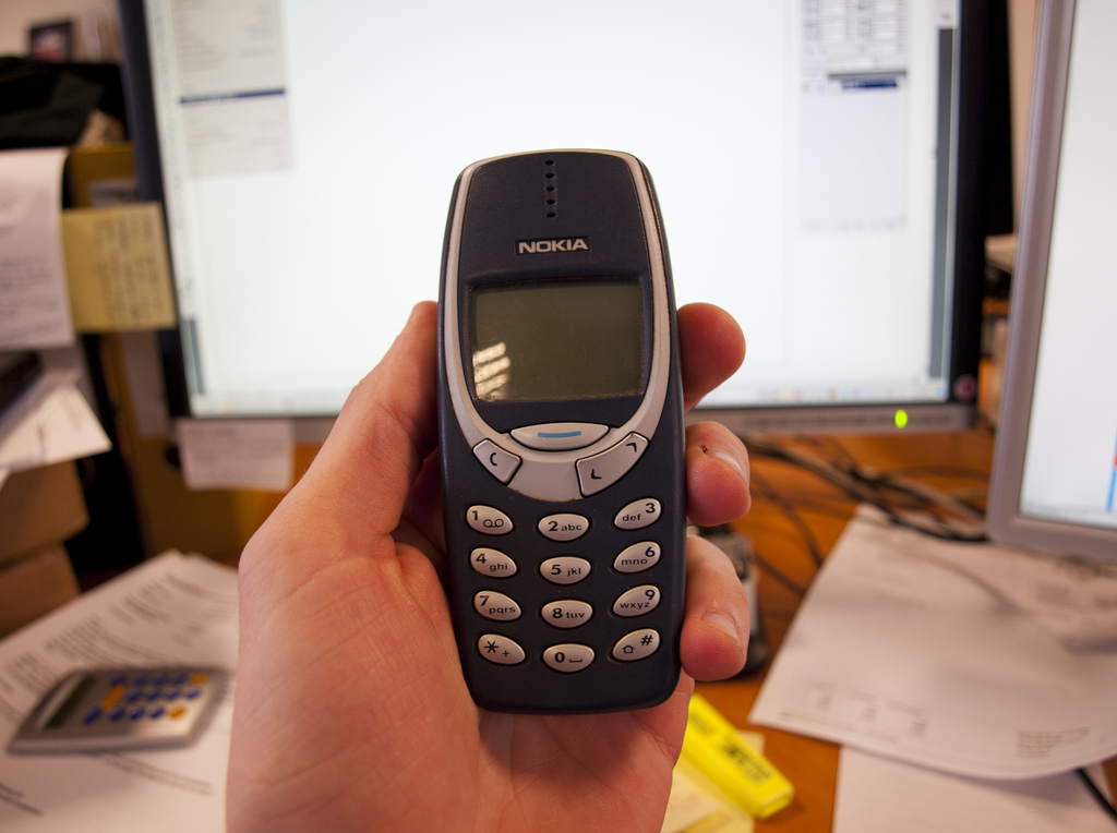 Front side of the old Nokia 3310 held in hand.