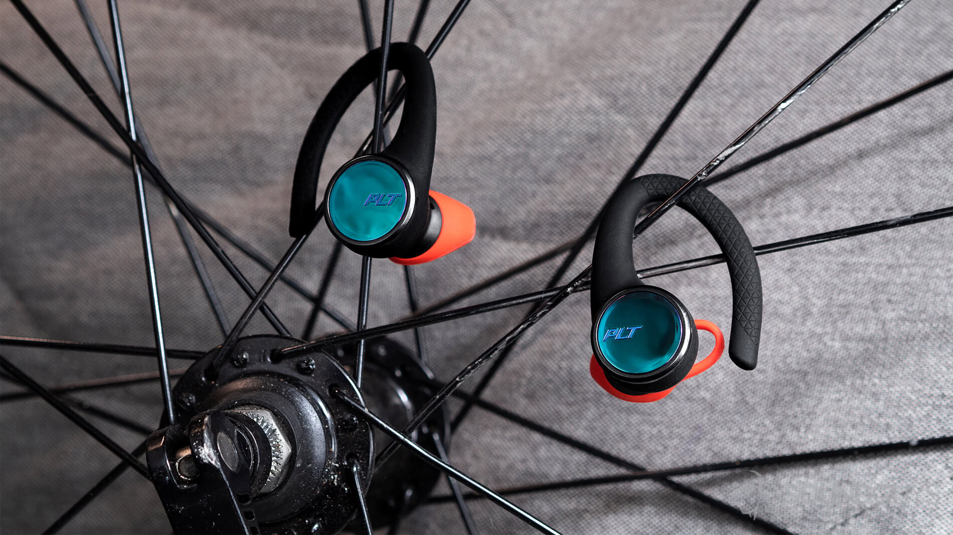 Poly BackBeat Fit 3100 true wireless earbuds on bike spokes.