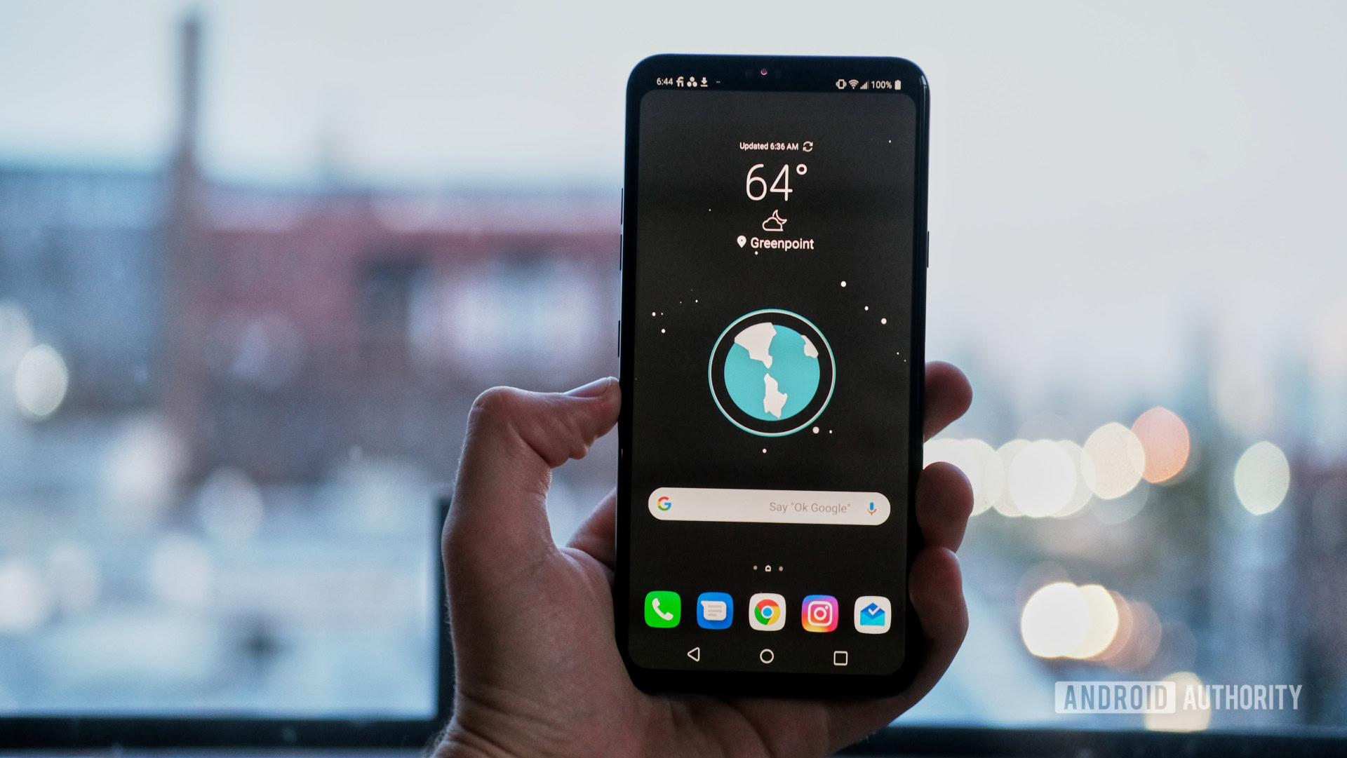 LG V40 ThinQ in hand showing home screen