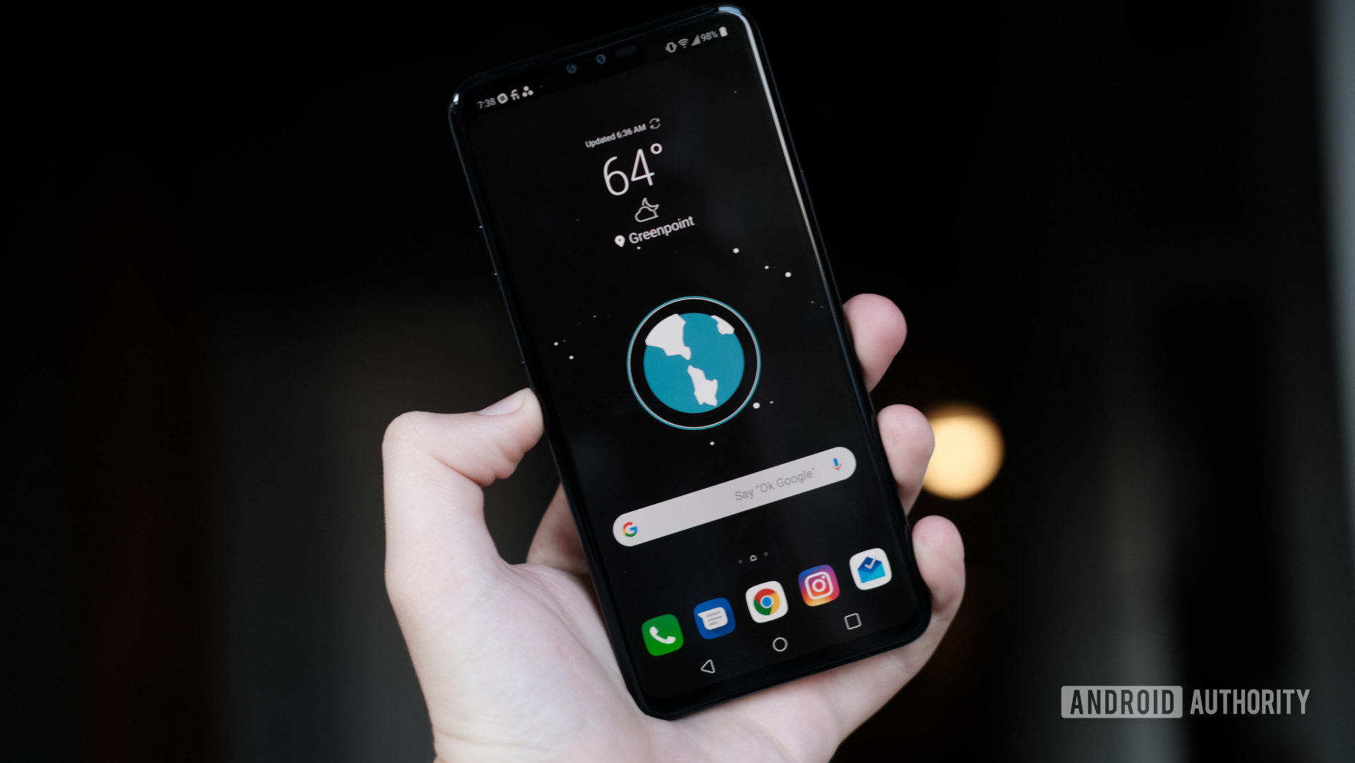 LG V40 ThinQ in hand showing home screen
