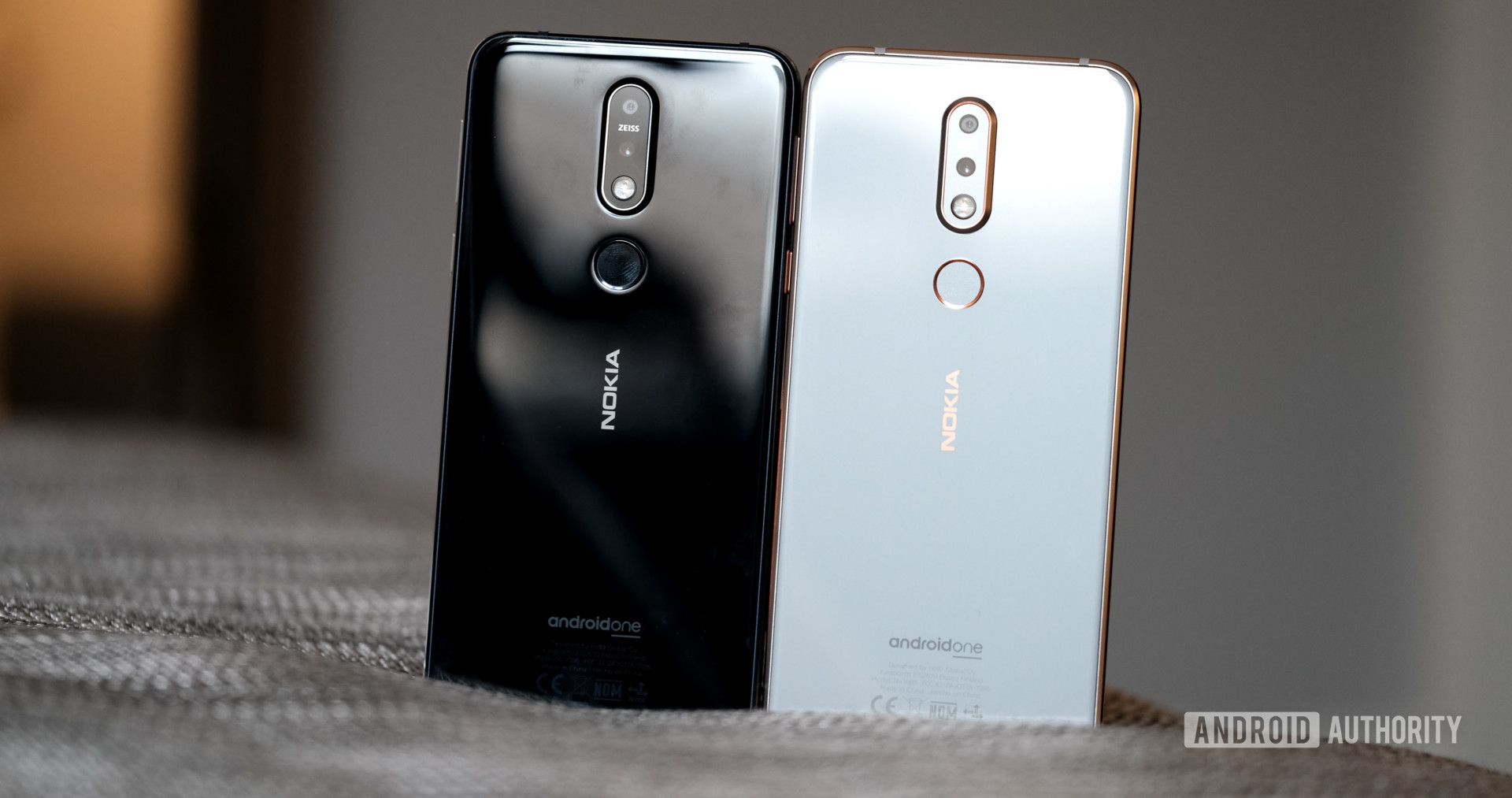 Backside of two Nokia 7.1 smartphones in white and black color.