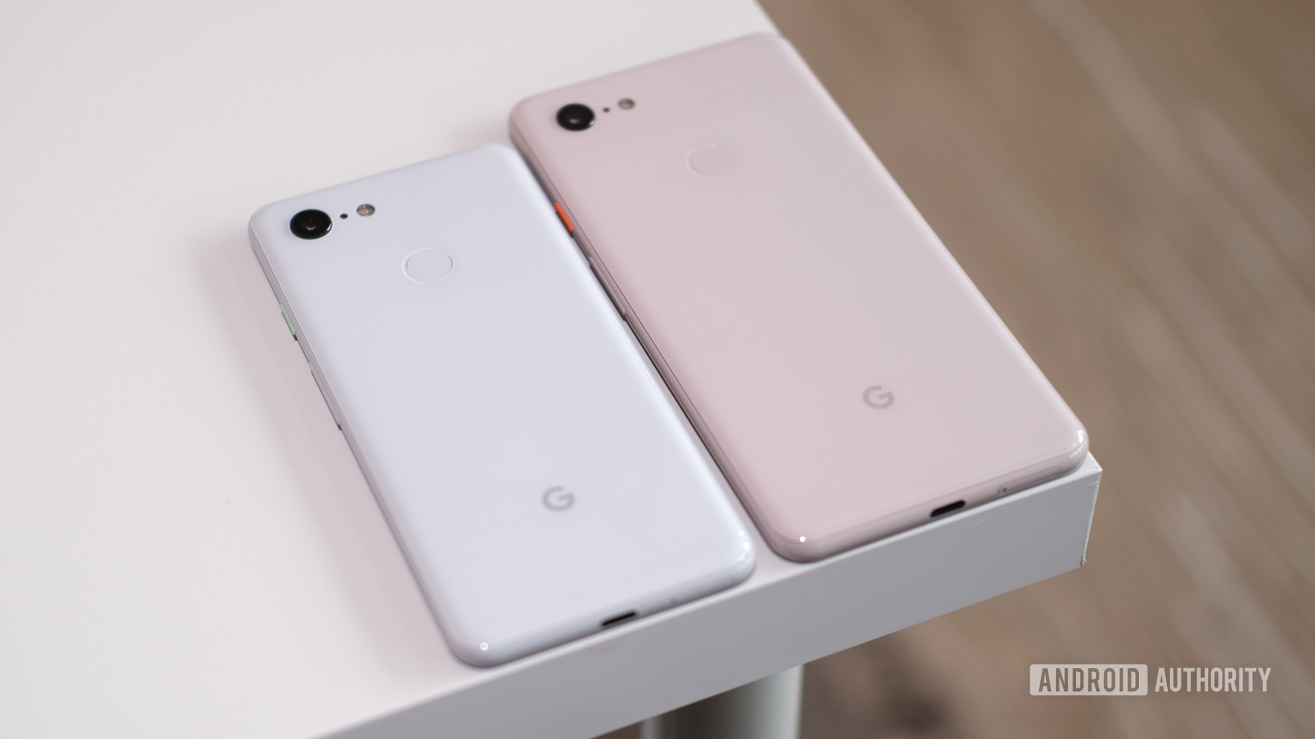 Google Pixel 3 in white and Pixel 3 XL in pink side-by-side on a table.