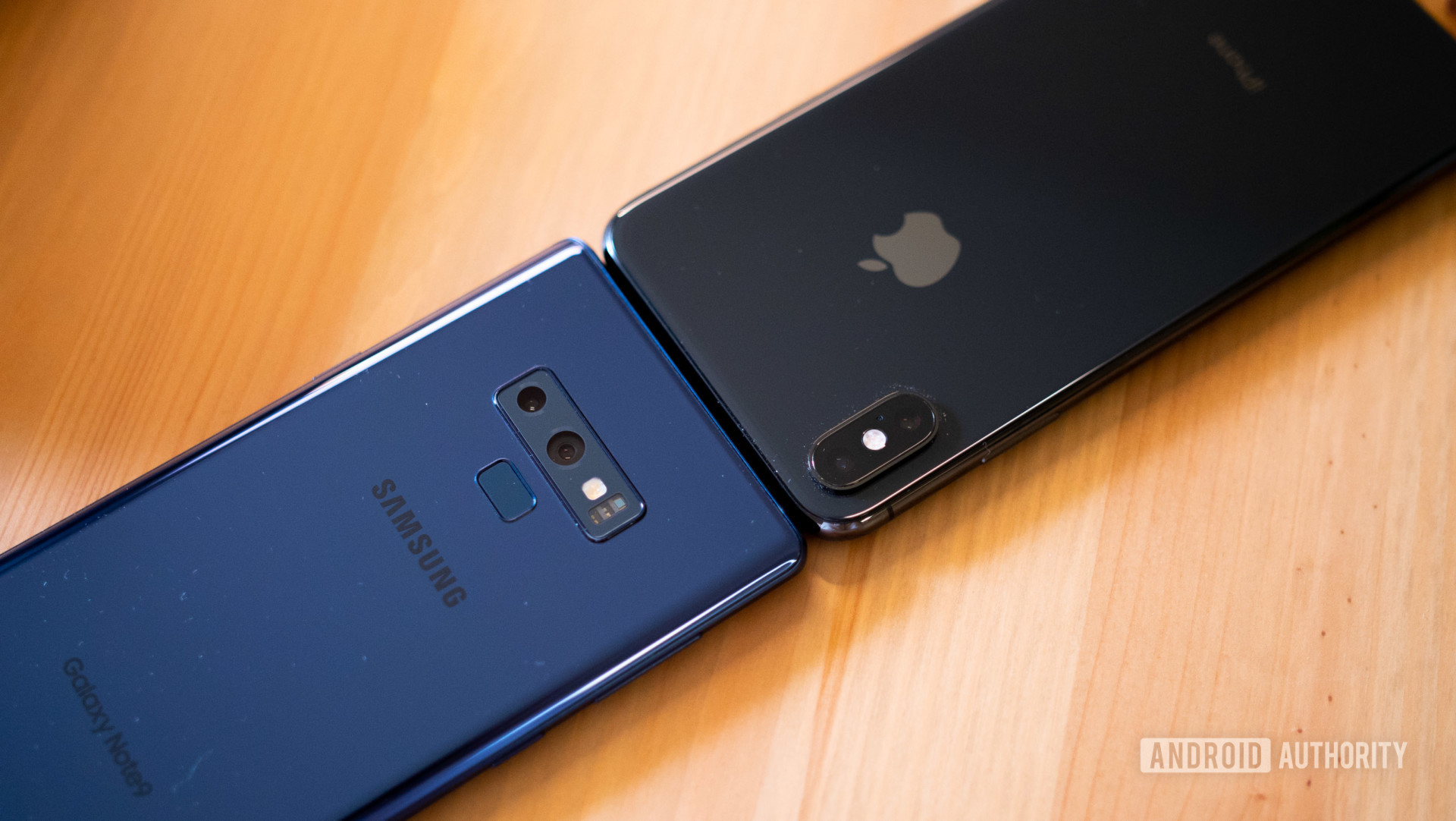 A Samsung and Apple smartphone pitted head to head on a table.