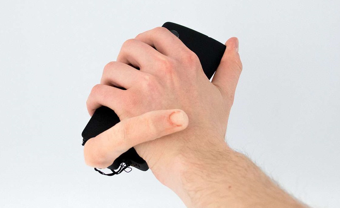 A person holding a phone with a finger attachment connected to it. 
