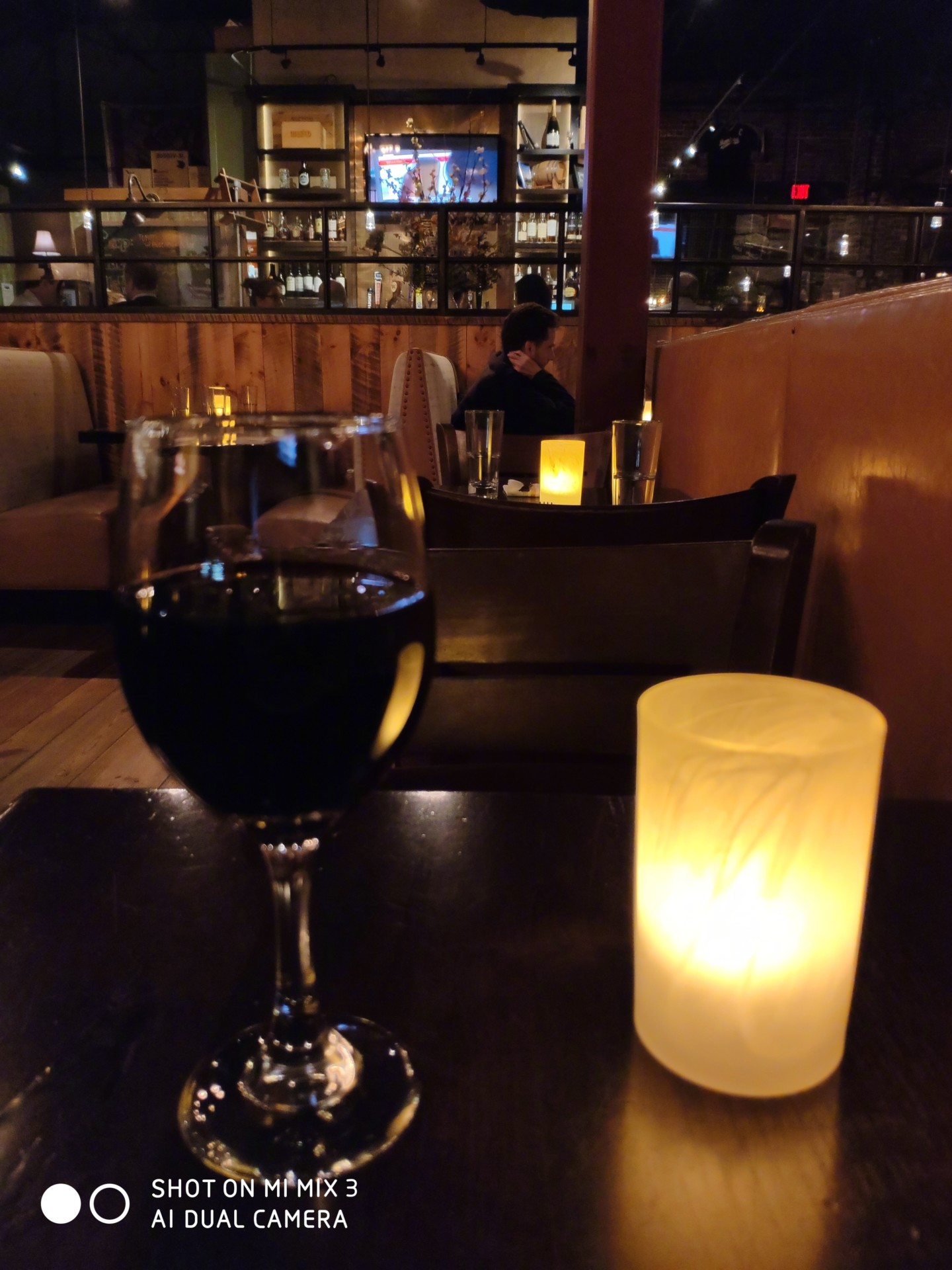 A glass of wine and a candle shot in a restaurant by the Mi Mix 3.