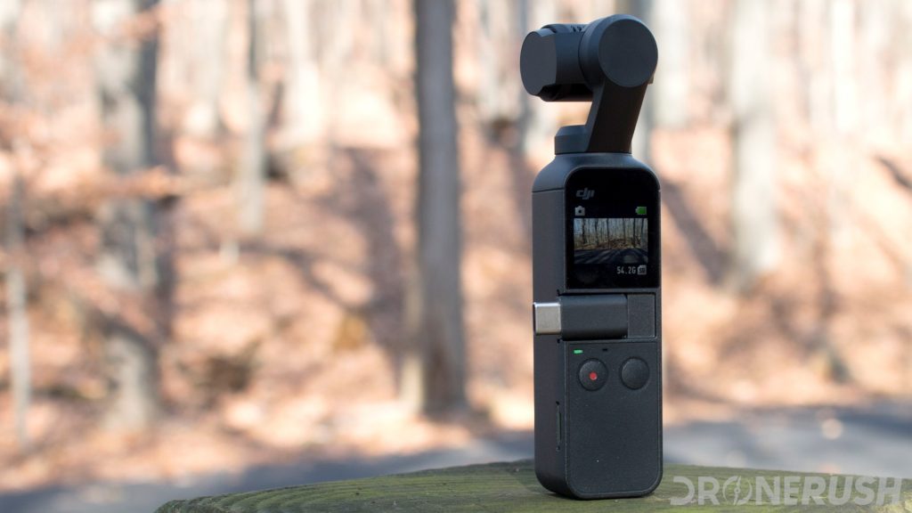 The DJI Osmo Pocket on a wooden post in a forest.