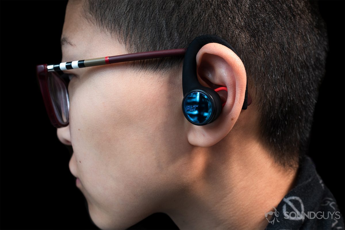 Poly BackBeat Fit 3100: A woman wearing the earbuds in profile view to show the size.