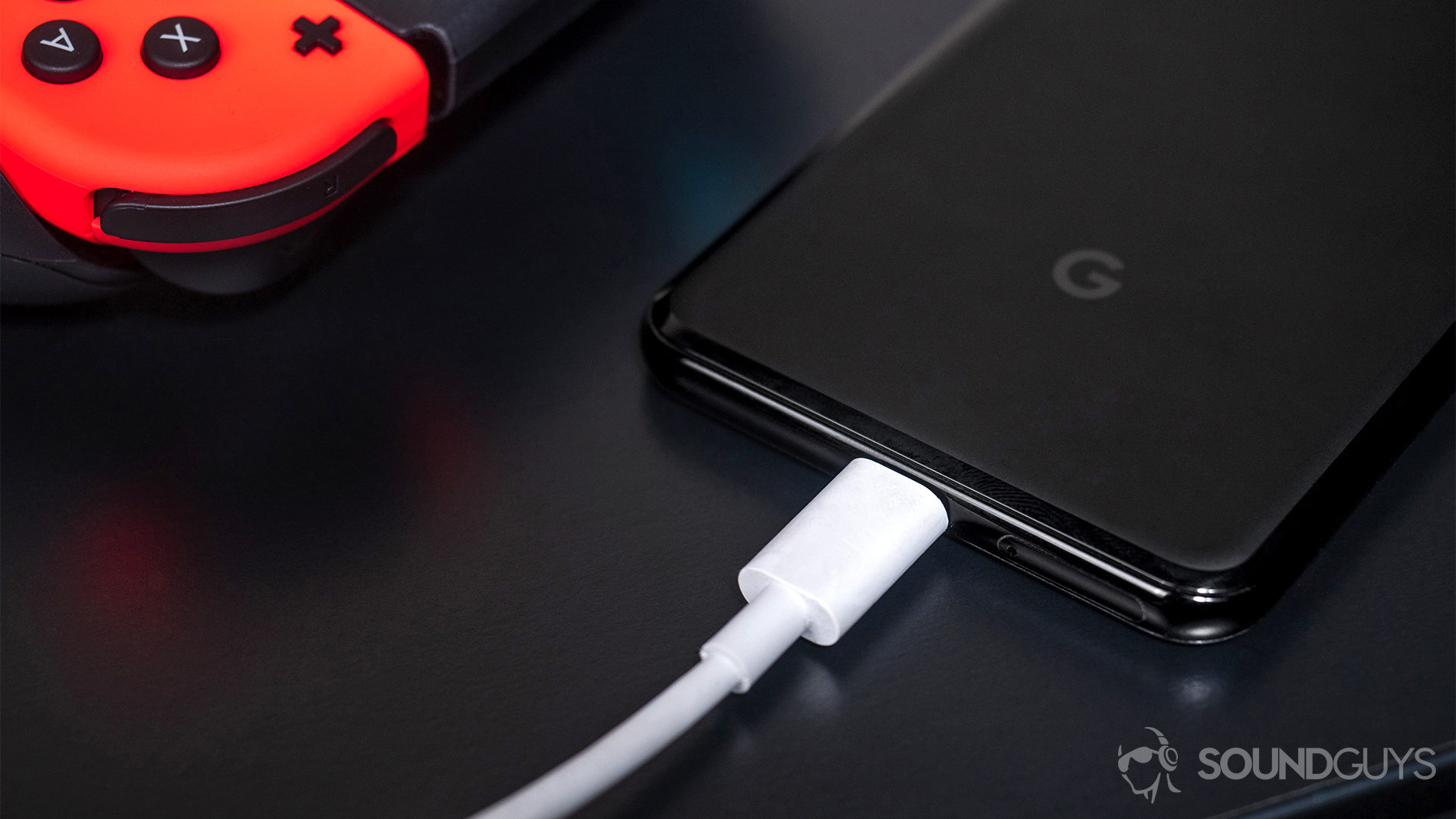 USB-C, headphone jack: Google Pixel 3 with USB-C headphones connected and Nintendo Switch controller in top left corner of image.