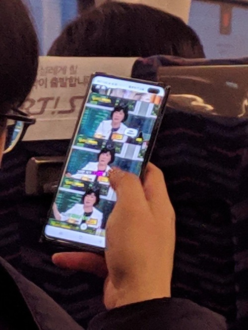 Samsung Galaxy S10 Plus in a person's hand on a bus.