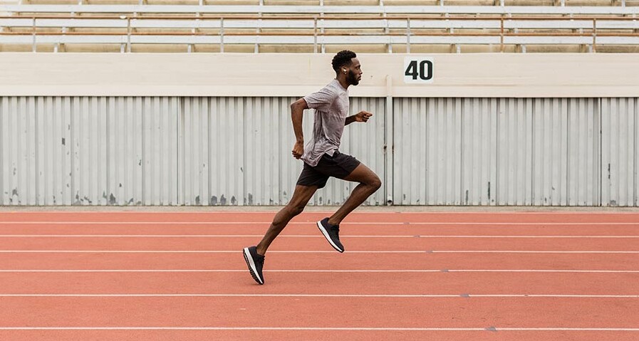 A man running on a track with the Jaybird Run XT.