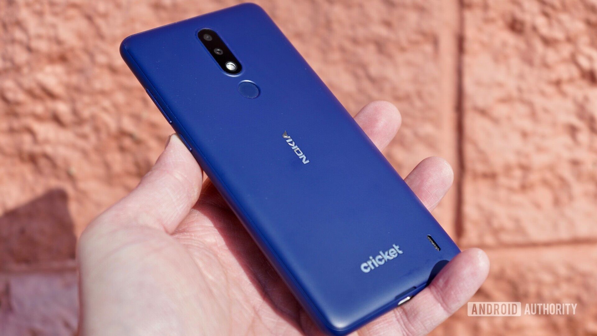Back side view of the Blue Nokia 3.1 Plus held in a hand.