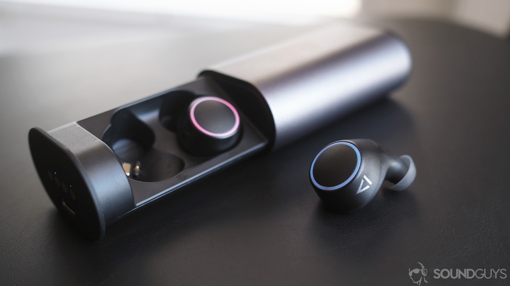 Creative Outlier Air true wireless earbuds with one in the case and the other resting just outside of it.