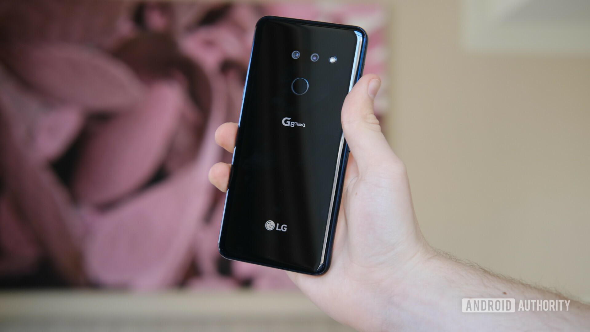 Back side photo of the LG G8 ThinQ held in a hand.