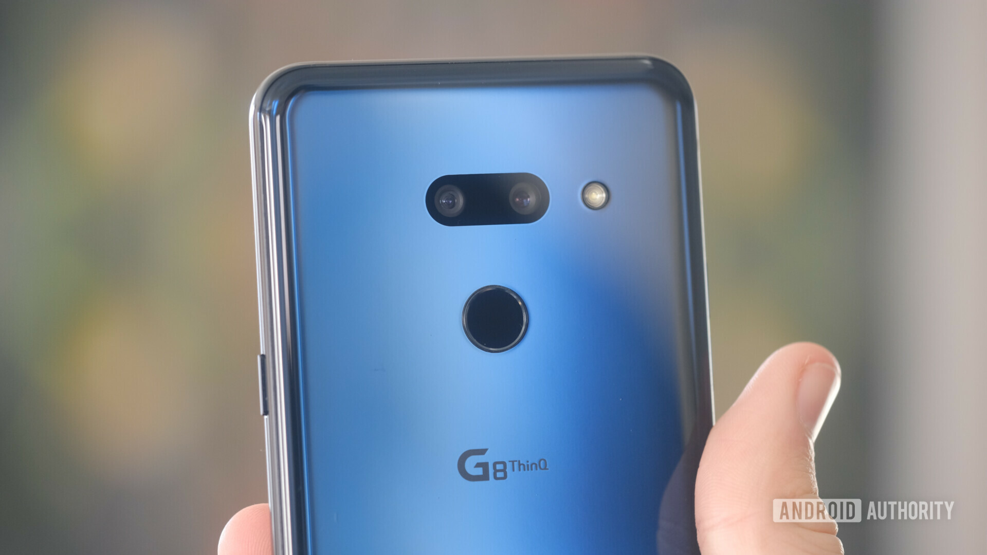 Backside of a blue LG G8 ThinQ held in a hand