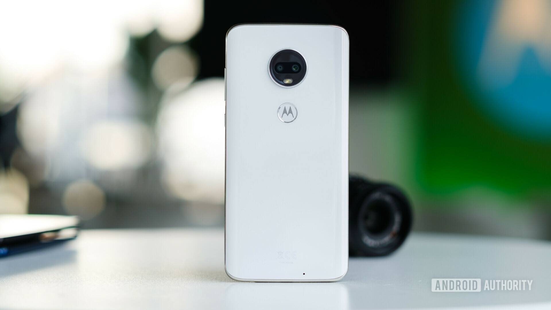 Back side of the new Motorola Moto G7 in white color standing upright on a desk.