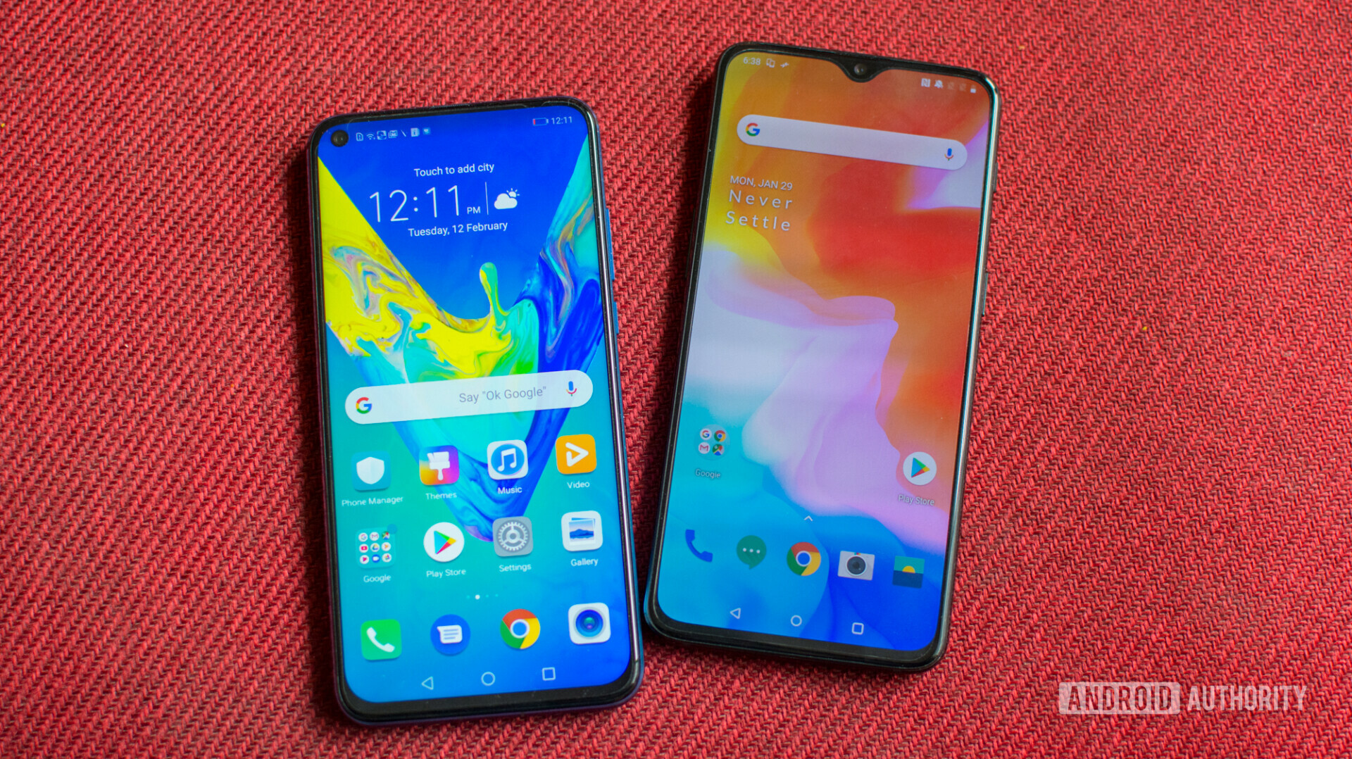 Photo of the front side of OnePlus 6T next to HONOR View 20 with displays turned on/