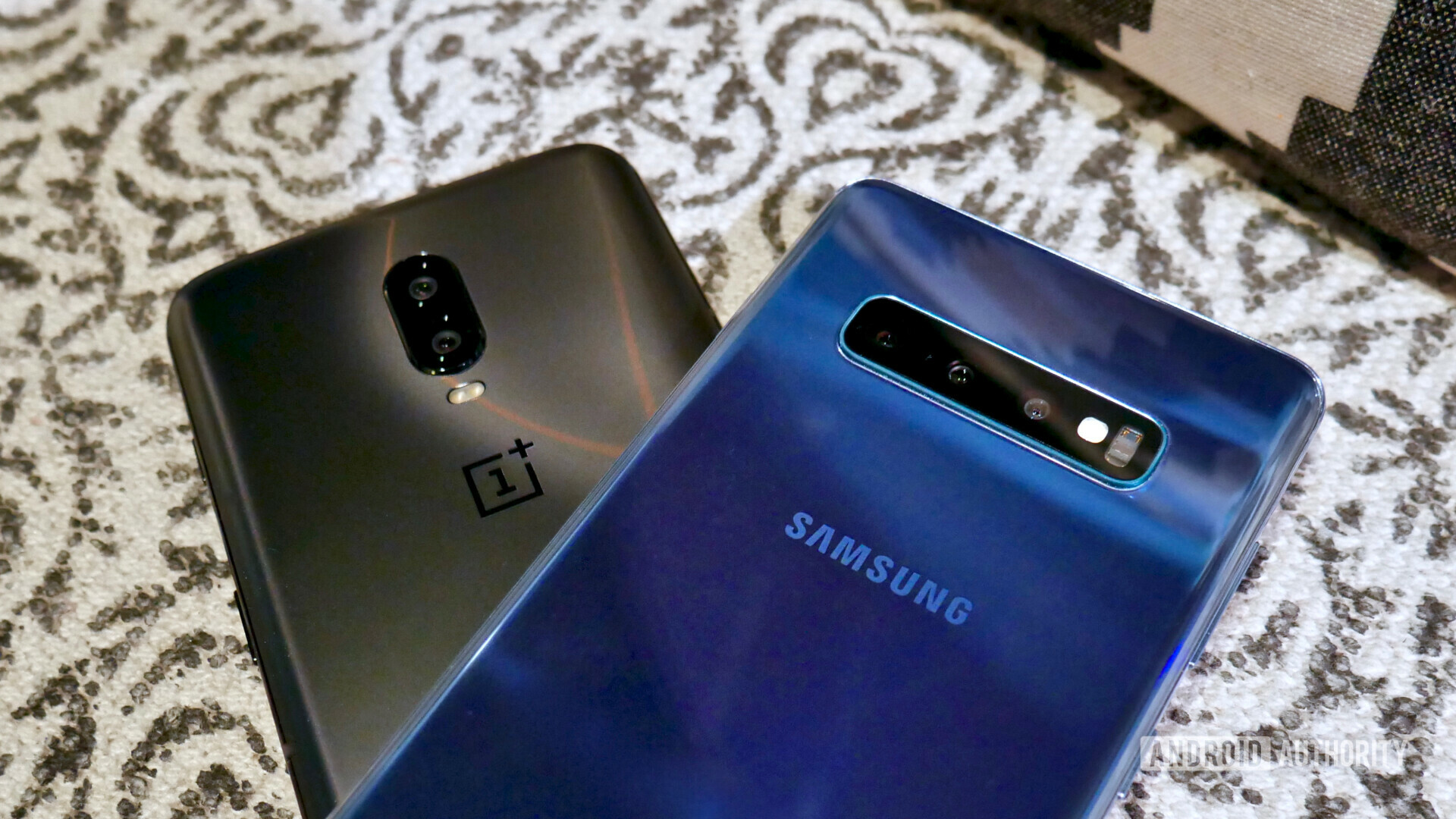 Backside of the Samsung Galaxy S10 next to an OnePlus 6T focusing on the cameras.