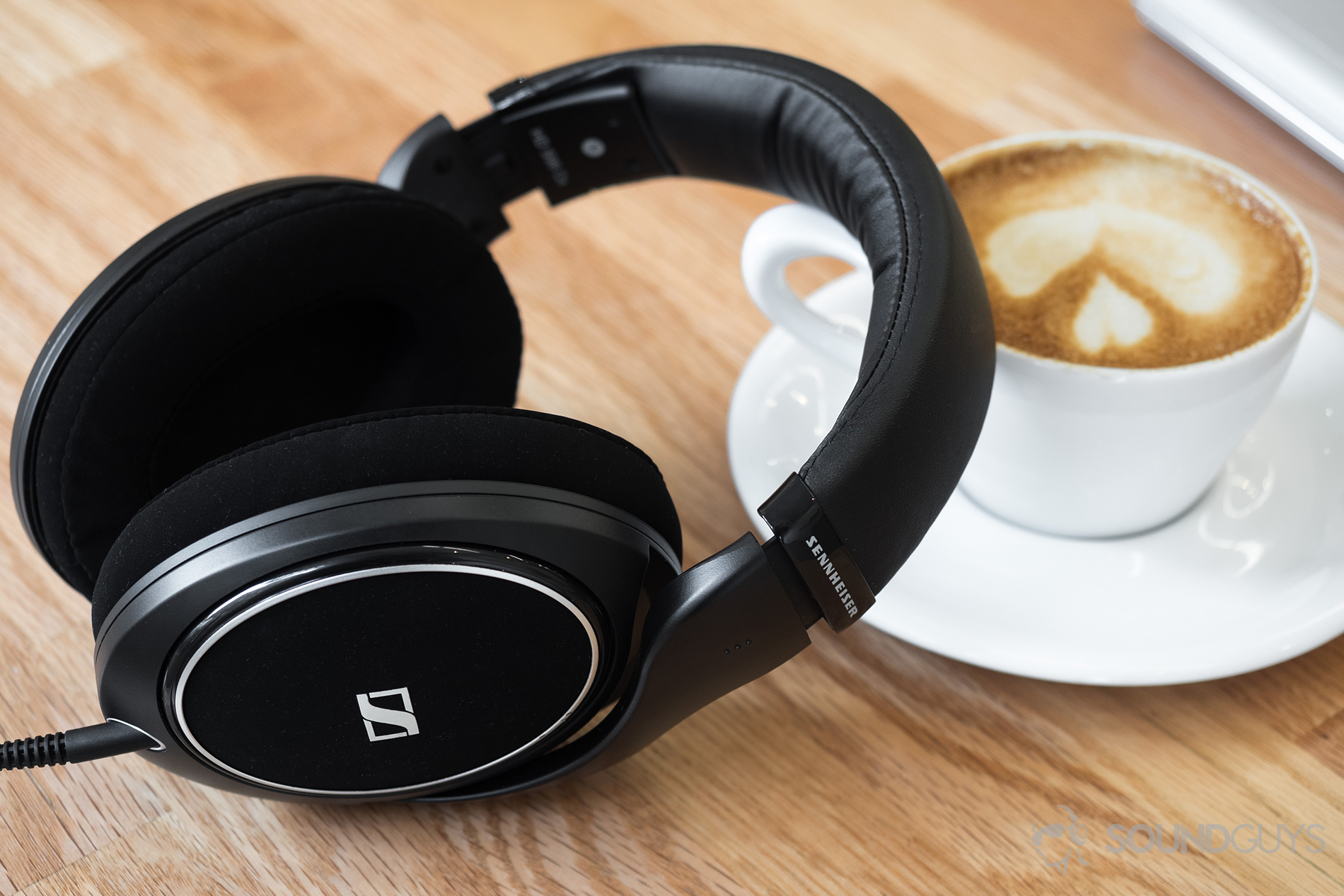 Samsung Galaxy S10 headphone: Sennheiser HD 598 CS headphones leaning against a latte on a wooden table.