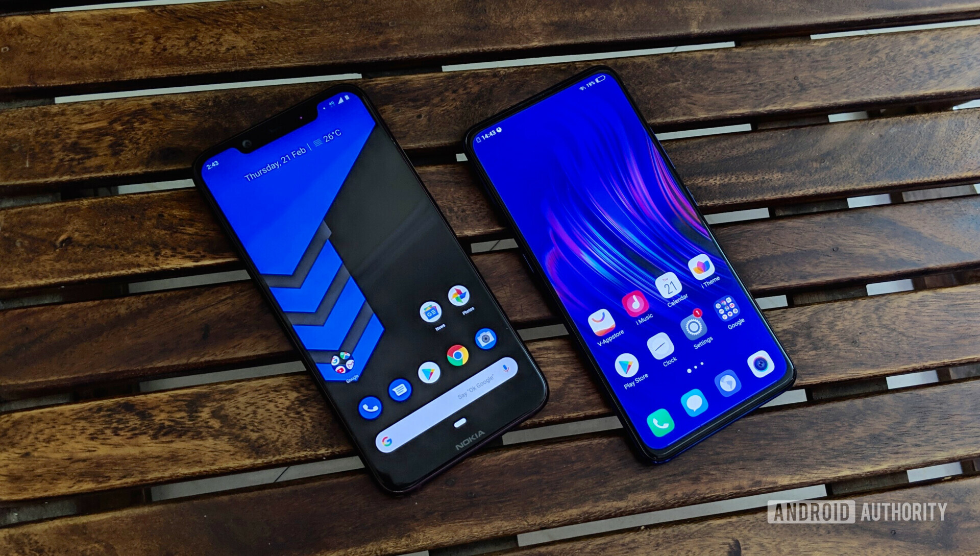 Frontside photo of the Vivo V15 Pro next to a Nokia 8.1 layed on a bench with displays turned on.