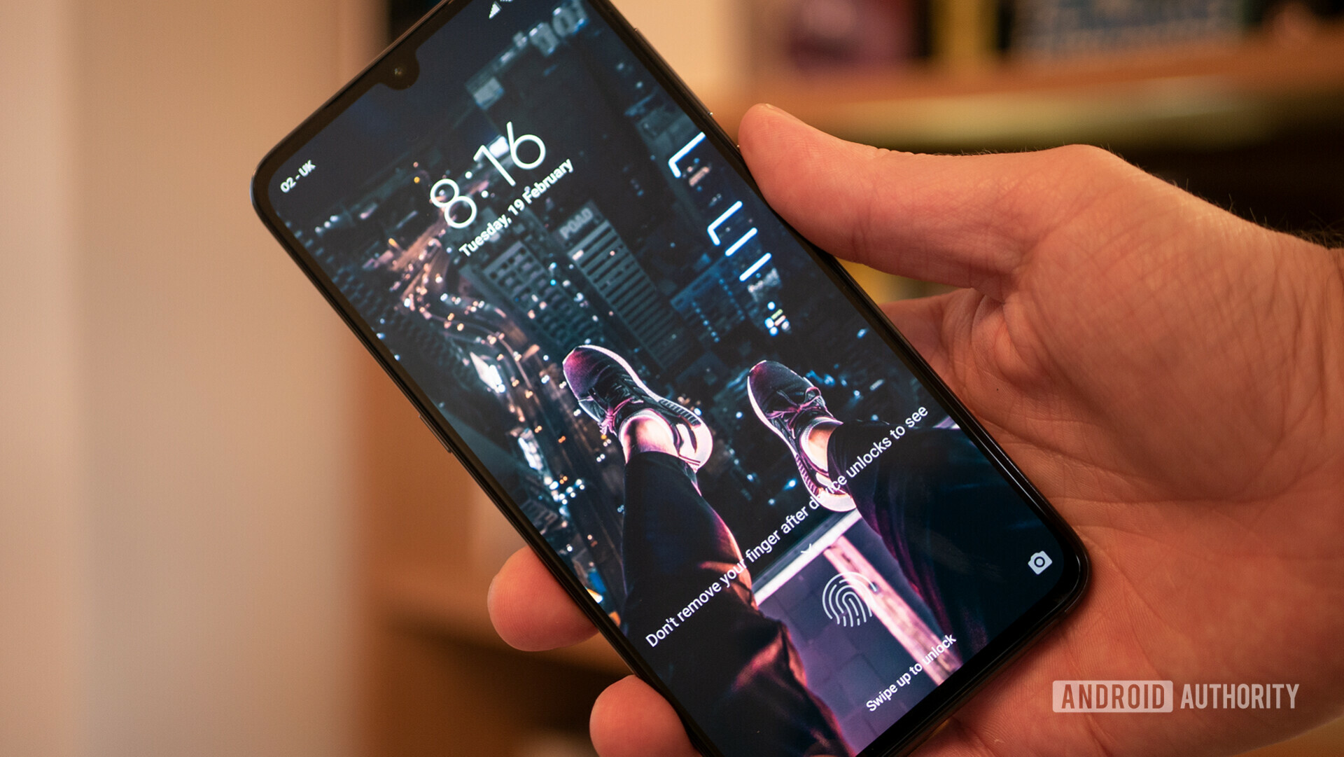 Photo of a black Xiaomi Mi 9 held in a hand displaying the Fingerprint Sensor