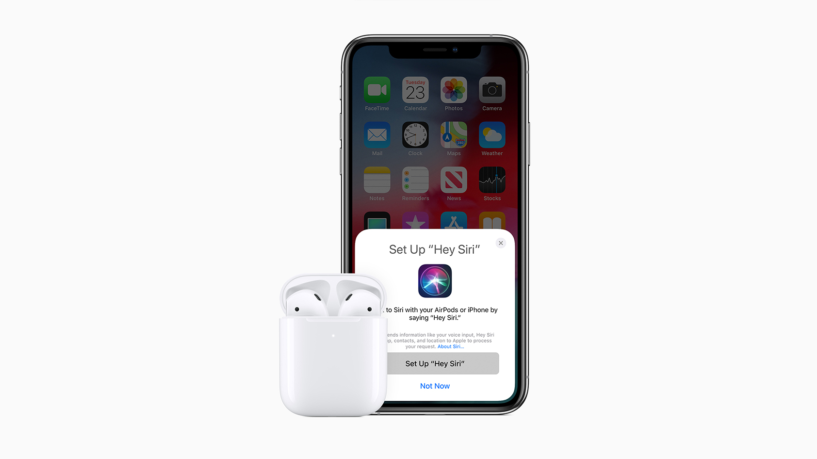 Second generation AirPods against an iPhone with Siri pulled up on the screen.
