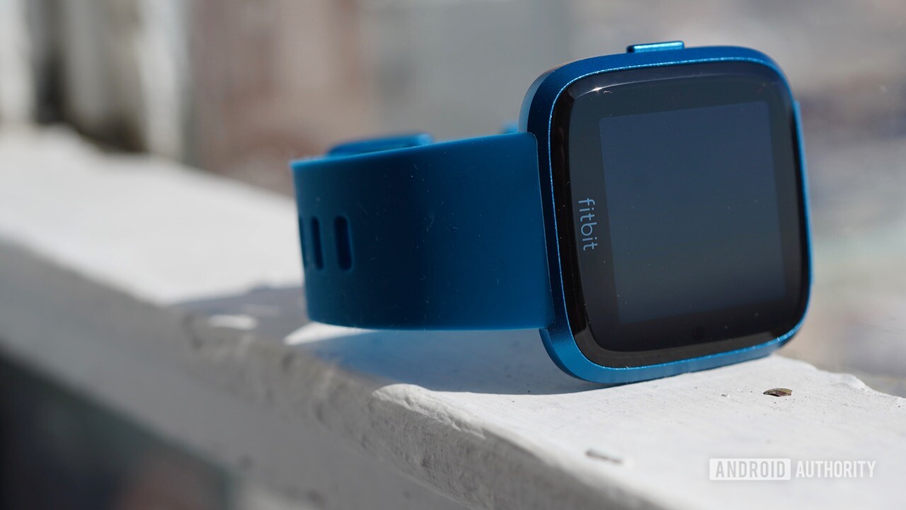 Fitbit Versa Lite with a blue strap.