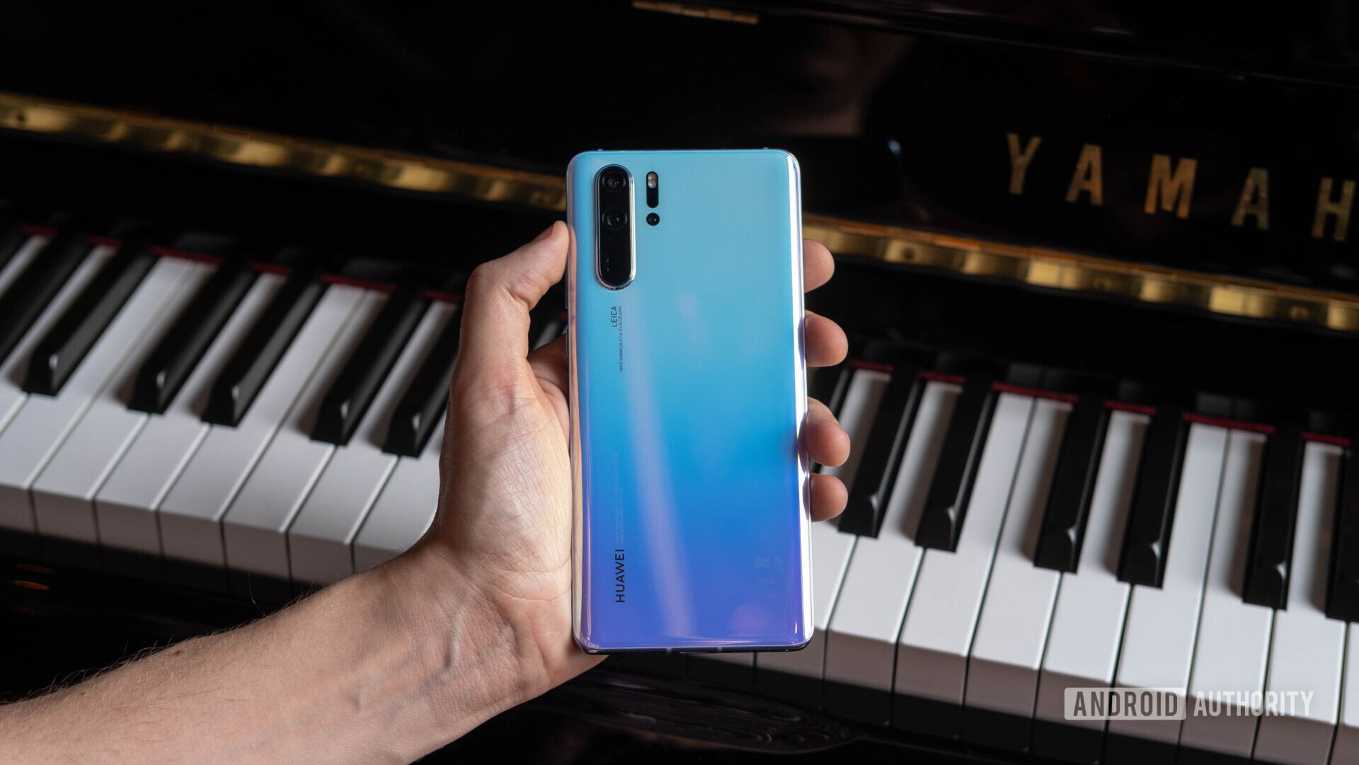Back side of a blue Huawei P30 Pro held in hand.