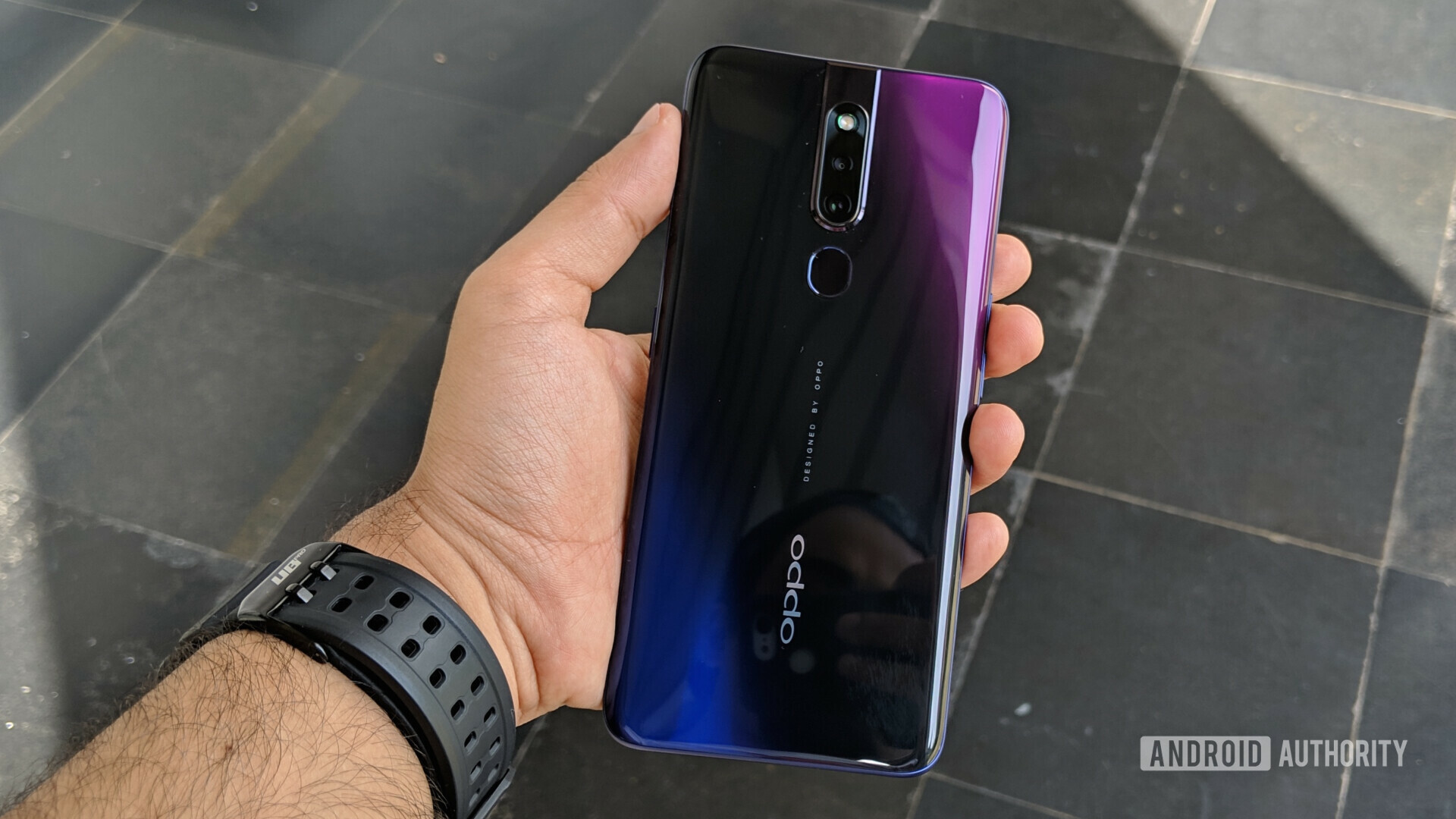 Backside of the oppo f11 pro held in a hand showing the dual cameras and fingerprint sensor.