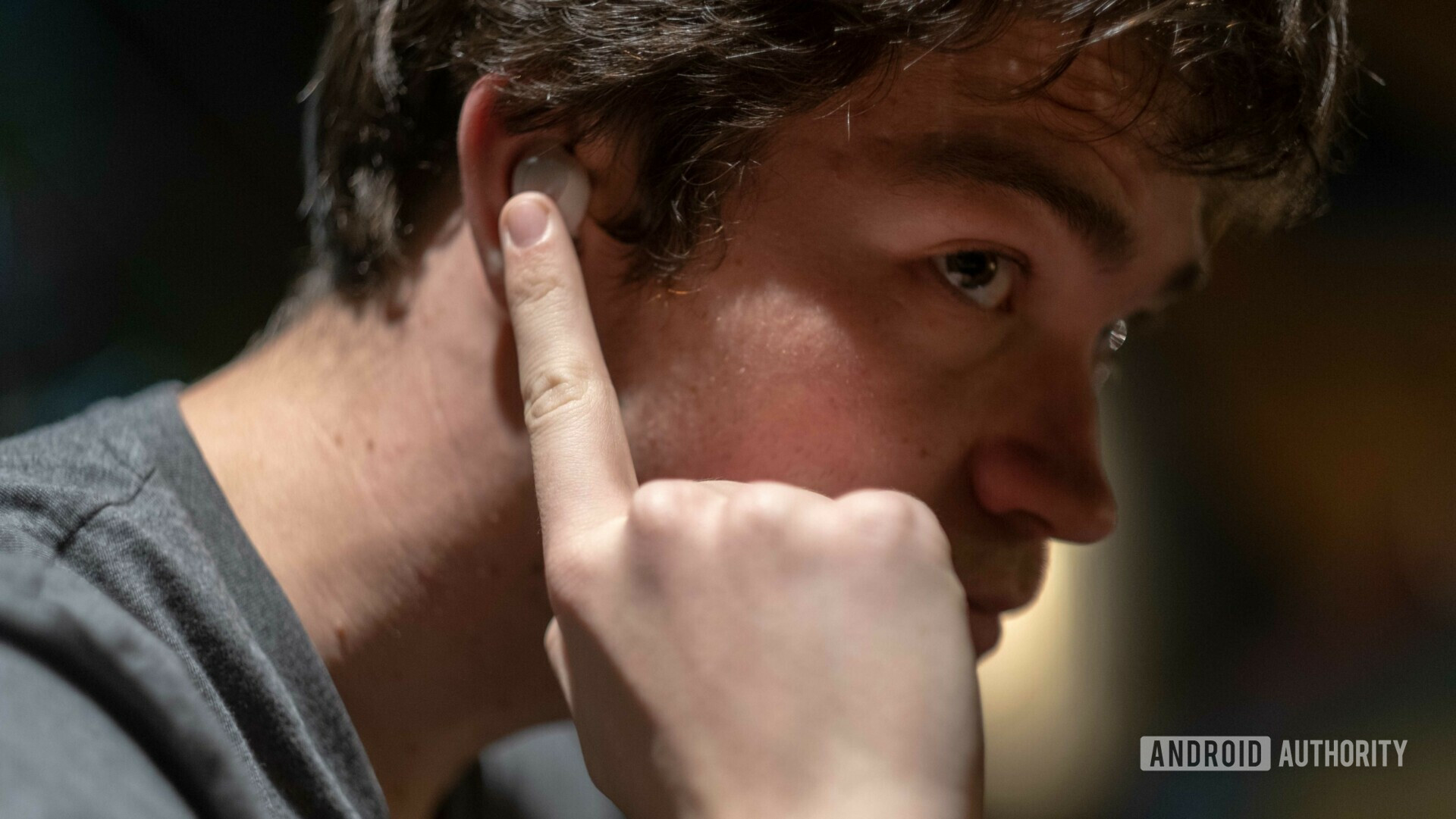 Samsung Galaxy Buds worn by a man using the touch controls