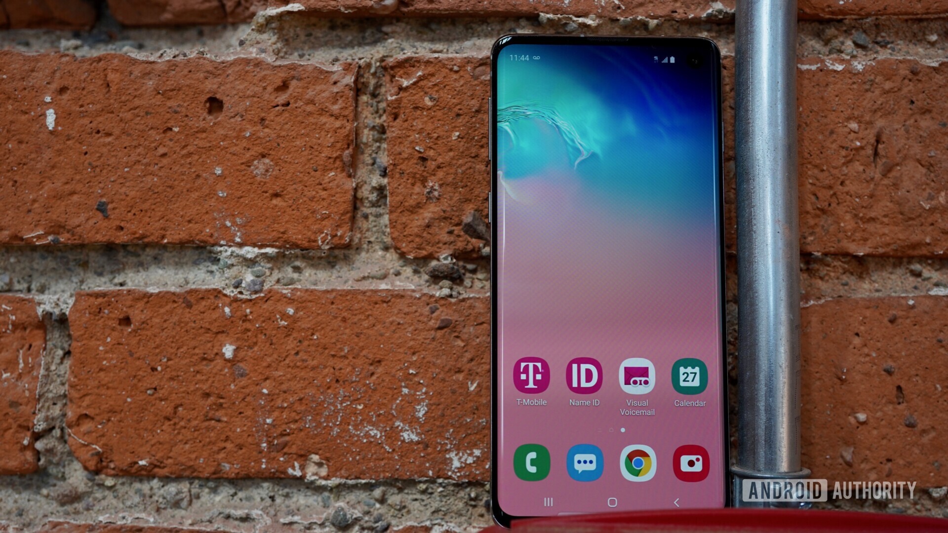 Front side of the Samsung Galaxy S10 against a brick wall.