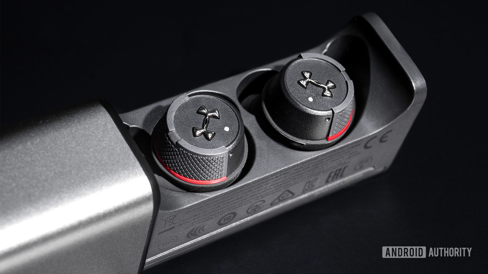 Under Armour True Wireless Flash JBL: Close up of the earbuds in the case with it sliding out.