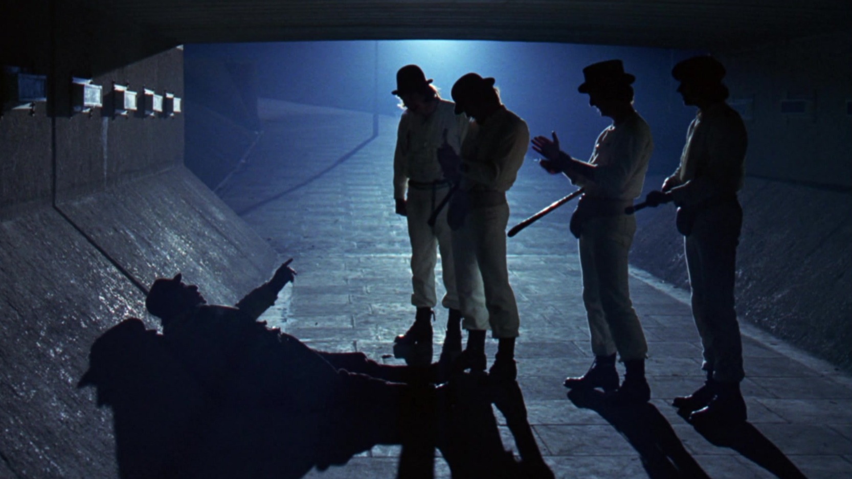 four men stand over a homeless person in A Clockwork Orange movie - best sci-fi movies on Netflix
