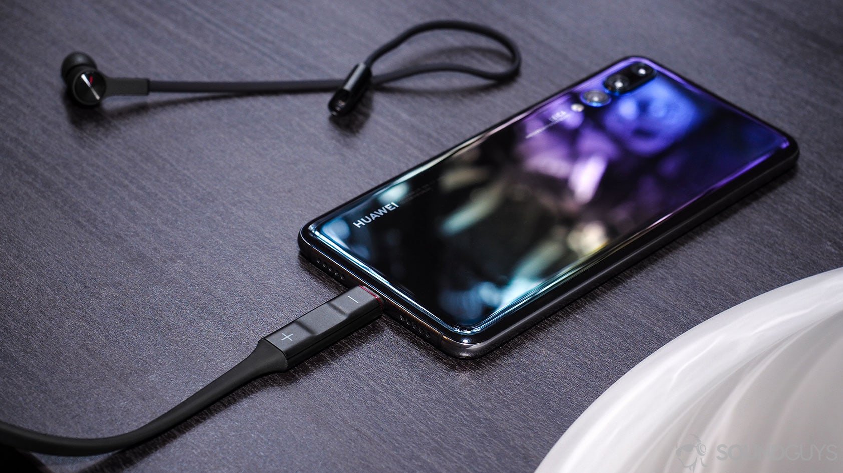 Huawei Freelace: Right earbud detached from the neckband which is plugged into a Huawei P20 smartphone via the USB-C plug.