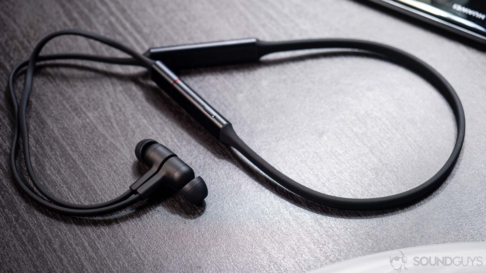 Huawei Freelace: Full shot of the neckband earbuds on a wooden surface.