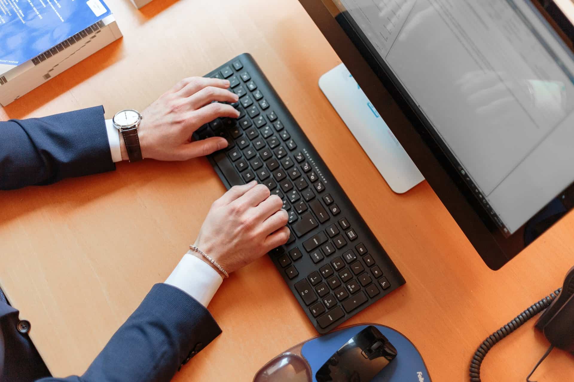 Man in Suit Typing on Keyboard