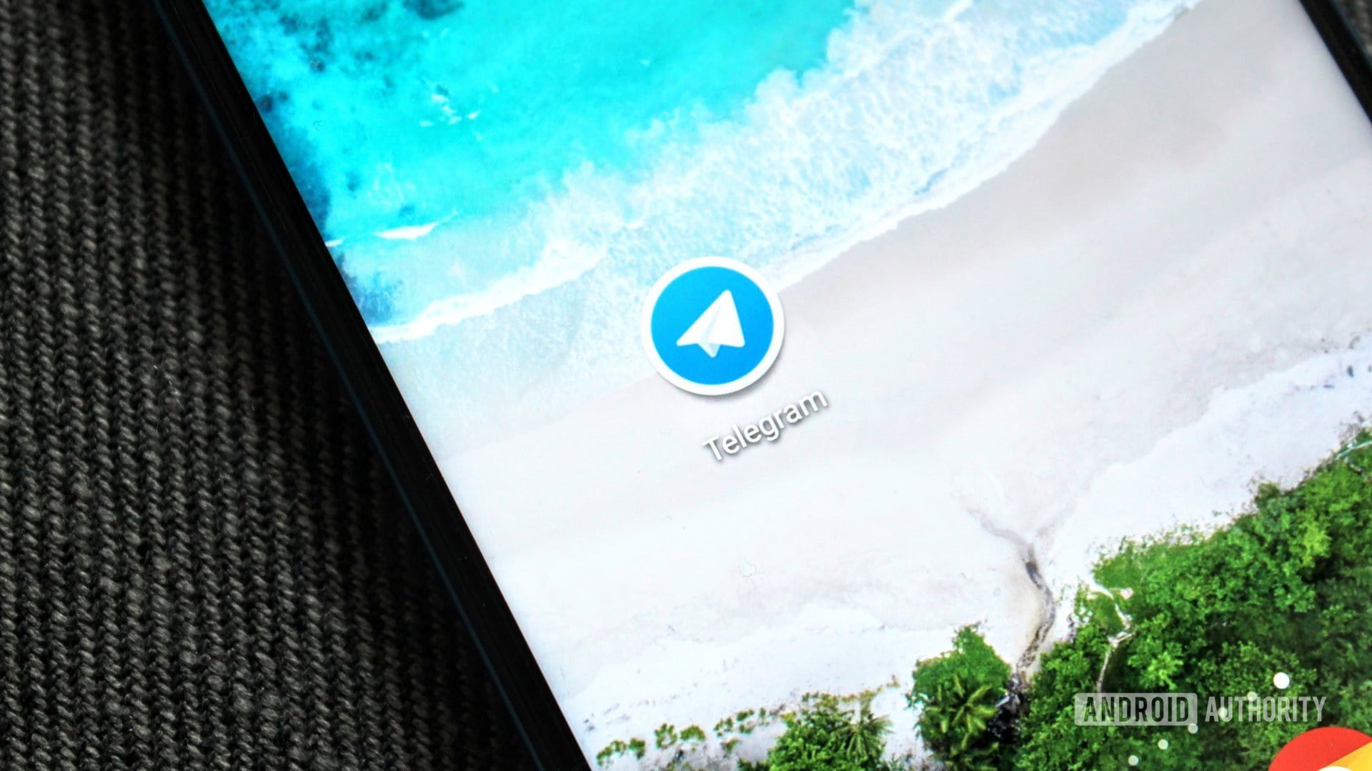 The Telegram icon on an HONOR View 20 on a blue background.